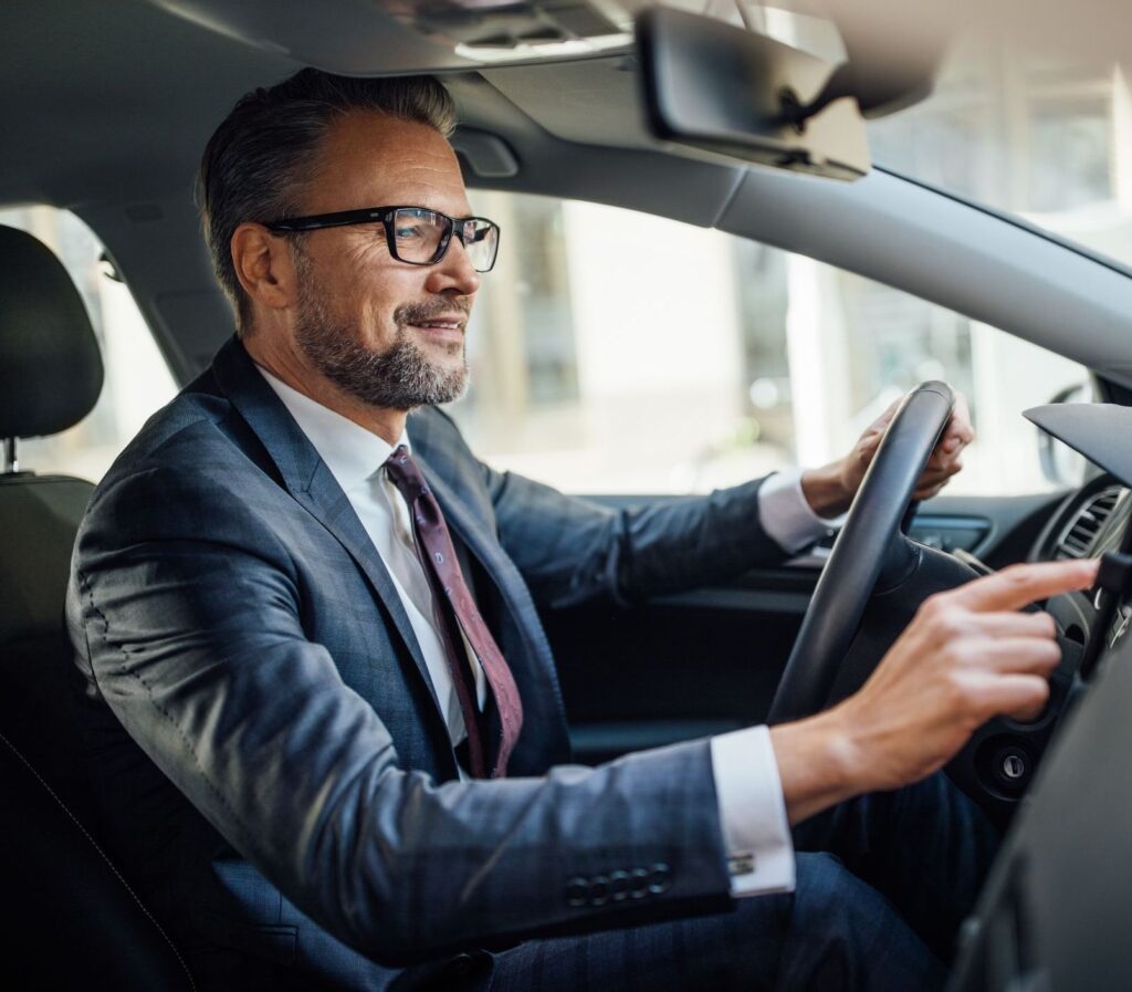 Business man confidently driving his car, auto insurance services